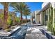 Modern home exterior featuring a water feature, desert landscaping, and sleek architectural design at 535 Serenity Point Dr, Henderson, NV 89012