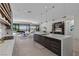 Open-concept kitchen with an island, seating, views of the living room, and access to the outdoor dining area at 535 Serenity Point Dr, Henderson, NV 89012
