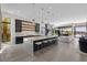 Spacious open-concept kitchen with an oversized island, barstool seating, and views into the living room and outdoor patio at 535 Serenity Point Dr, Henderson, NV 89012