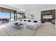 Bright living room with a large white sectional couch, wet bar, and expansive windows showcasing beautiful outdoor views at 535 Serenity Point Dr, Henderson, NV 89012