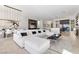 Open concept living room featuring a large white sectional sofa, modern light fixture, and sophisticated decor at 535 Serenity Point Dr, Henderson, NV 89012