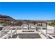 Stunning outdoor patio featuring comfortable seating, a modern fire pit, and panoramic views of the mountain and golf course at 535 Serenity Point Dr, Henderson, NV 89012