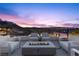 Elegant outdoor patio area with a fire pit, cozy seating, and a breathtaking view of the city skyline at sunset at 535 Serenity Point Dr, Henderson, NV 89012