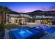 Outdoor area with a pool and spa, illuminated by night lighting and mountain views at 535 Serenity Point Dr, Henderson, NV 89012