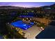 Aerial view showcasing a modern pool with in-water seating, a hot tub, and a cozy outdoor fireplace area at 535 Serenity Point Dr, Henderson, NV 89012