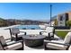 Relaxing pool area with a fire pit, comfortable seating, and picturesque views of the mountains in the background at 535 Serenity Point Dr, Henderson, NV 89012