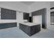 Unfinished modern kitchen featuring dark cabinets, a large island, and sleek design elements at 563 Rock Peak Dr, Henderson, NV 89012
