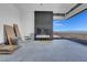 Living room featuring a sleek, modern fireplace and expansive windows showcasing scenic views at 563 Rock Peak Dr, Henderson, NV 89012