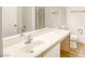 Bright bathroom with a single sink vanity, large mirror, and a combined shower and tub with glass doors at 5751 E Hacienda Ave # 243, Las Vegas, NV 89122