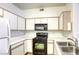 Bright kitchen with black appliances, white cabinets, and stainless steel sink at 5751 E Hacienda Ave # 243, Las Vegas, NV 89122
