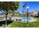 Outdoor pool surrounded by lush landscaping, lounge chairs, and shade trees, perfect for community recreation at 5751 E Hacienda Ave # 243, Las Vegas, NV 89122