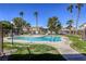 Community swimming pool surrounded by palm trees, seating, and well-maintained landscaping, perfect for leisure at 5751 E Hacienda Ave # 243, Las Vegas, NV 89122
