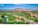 Scenic aerial view of lush golf course with mature trees, serene ponds, and mountain backdrop on a sunny day at 6076 Wheat Penny Ave, Las Vegas, NV 89122
