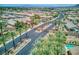 Gated community featuring single-story homes with desert landscaping and a community pool in the distance at 6076 Wheat Penny Ave, Las Vegas, NV 89122