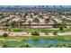 Aerial view of a community featuring desert landscaping, a pond, and golf course in the distance at 6076 Wheat Penny Ave, Las Vegas, NV 89122