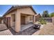 Back yard featuring brick pavers, covered patio with ceiling fan, fire pit, and desert landscaping at 6076 Wheat Penny Ave, Las Vegas, NV 89122