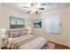 Staged bedroom with light-colored walls, wood-look floors, ceiling fan, and window with bright natural light at 6076 Wheat Penny Ave, Las Vegas, NV 89122