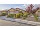 Single story home featuring desert landscaping with shrubs, rock, and mature trees at 6076 Wheat Penny Ave, Las Vegas, NV 89122