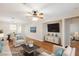 Bright living room featuring hardwood floors, stylish furniture, a ceiling fan, and a mounted flat screen TV at 6076 Wheat Penny Ave, Las Vegas, NV 89122