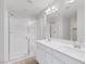 Bright bathroom with double vanity, large mirrors, and a glass enclosed shower stall at 6276 Desert Orchid Way, Las Vegas, NV 89141