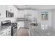 Modern kitchen featuring granite countertops, stainless steel appliances and tiled floor at 6276 Desert Orchid Way, Las Vegas, NV 89141