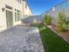The backyard features a brick patio, artificial turf, rock landscaping, and a block wall fence at 629 Soaring Wings Ave, Las Vegas, NV 89183