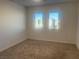 Carpeted bedroom with natural light from two windows; blank canvas ready for your personal touch at 629 Soaring Wings Ave, Las Vegas, NV 89183