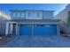 Two-story home featuring a gray exterior and a striking blue two-car garage door, complemented by a paved driveway at 629 Soaring Wings Ave, Las Vegas, NV 89183