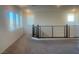 Carpeted loft area with railing and plenty of natural light from several windows at 629 Soaring Wings Ave, Las Vegas, NV 89183