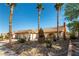Desert-landscaped home featuring mature trees, rock beds, and a charming two-car garage at 6509 Vicuna Dr, Las Vegas, NV 89146