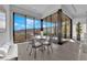 Sunlit dining area featuring a modern table set and panoramic views through expansive windows at 658 Falcon Summit Ct, Henderson, NV 89012
