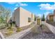 Modern house with well-maintained desert landscaping, a private walkway, and a tan facade at 658 Falcon Summit Ct, Henderson, NV 89012