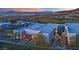 Contemporary home featuring a sleek facade, glass garage doors, and professionally landscaped grounds against a mountain backdrop at 658 Falcon Summit Ct, Henderson, NV 89012
