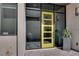 Stylish yellow front door with modern design and sidelight windows, enhancing curb appeal at 658 Falcon Summit Ct, Henderson, NV 89012