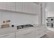 Bright modern kitchen featuring white cabinets, long countertops, and stainless steel appliances at 658 Falcon Summit Ct, Henderson, NV 89012