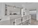 Modern kitchen featuring an island with seating, sleek white cabinets, and stainless steel appliances at 658 Falcon Summit Ct, Henderson, NV 89012