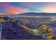 Hillside community with desert landscaping and stunning views of the city at dusk at 658 Falcon Summit Ct, Henderson, NV 89012