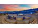 Circular patio with cozy seating and fire pit offering stunning views of the city and mountains at 658 Falcon Summit Ct, Henderson, NV 89012
