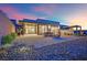 Modern home with expansive patio featuring a fire pit, outdoor seating, and desert landscaping at 658 Falcon Summit Ct, Henderson, NV 89012