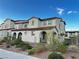Stunning white stucco townhome with arched entrances and desert landscaping at 727 Pickled Pepper Pl, Henderson, NV 89011