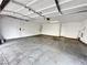 An empty two car garage with concrete flooring, white walls and door, and an automatic overhead door system at 727 Pickled Pepper Pl, Henderson, NV 89011