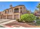 Charming multi-Gathering building showcasing a red tile roof, individual garages and lovely, mature landscaping at 7270 Sheared Cliff Ln # 104, Las Vegas, NV 89149