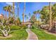 Beautiful pool entrance with lush landscaping, towering palm trees, and a paved walkway at 7270 Sheared Cliff Ln # 104, Las Vegas, NV 89149