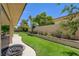 Spacious backyard featuring a covered patio, green lawn, and beautiful landscaping, creating a private outdoor oasis at 7613 Hackensack Ct, Las Vegas, NV 89128