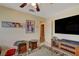 A spacious bedroom features a TV on the wall, neutral carpet and a ceiling fan for optimal comfort at 7613 Hackensack Ct, Las Vegas, NV 89128
