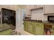 Kitchen with stainless steel appliances, a marble floor, and olive green cabinets at 7613 Hackensack Ct, Las Vegas, NV 89128