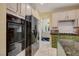 Kitchen showing updated appliances, marble floor, tiled backsplash, and green cabinets at 7613 Hackensack Ct, Las Vegas, NV 89128
