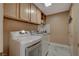 Functional laundry room with modern washer and dryer, ample cabinet space, and stylish marble-patterned flooring at 7613 Hackensack Ct, Las Vegas, NV 89128