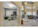Open-concept living room with marble floors, shutters, and high ceilings with eye-catching light fixtures at 7613 Hackensack Ct, Las Vegas, NV 89128