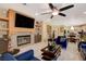 Cozy living room boasts a fireplace, TV, ceiling fan, and open kitchen view at 7613 Hackensack Ct, Las Vegas, NV 89128